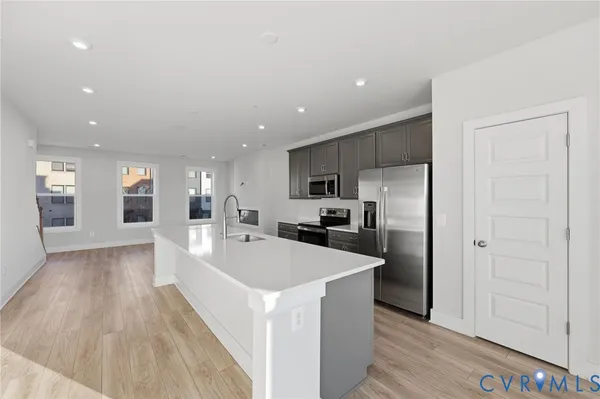 a large white kitchen with a large counter top appliances and cabinets