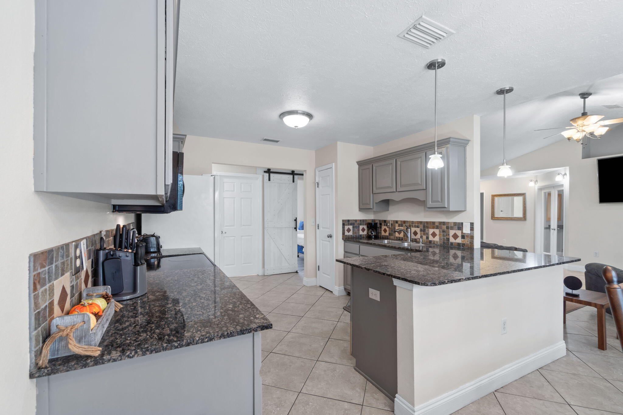 6983 Snug Waters Road Navarre, FL 32566 - Photo 18 of 48 a kitchen with stainless steel appliances granite countertop a sink stove and cabinets