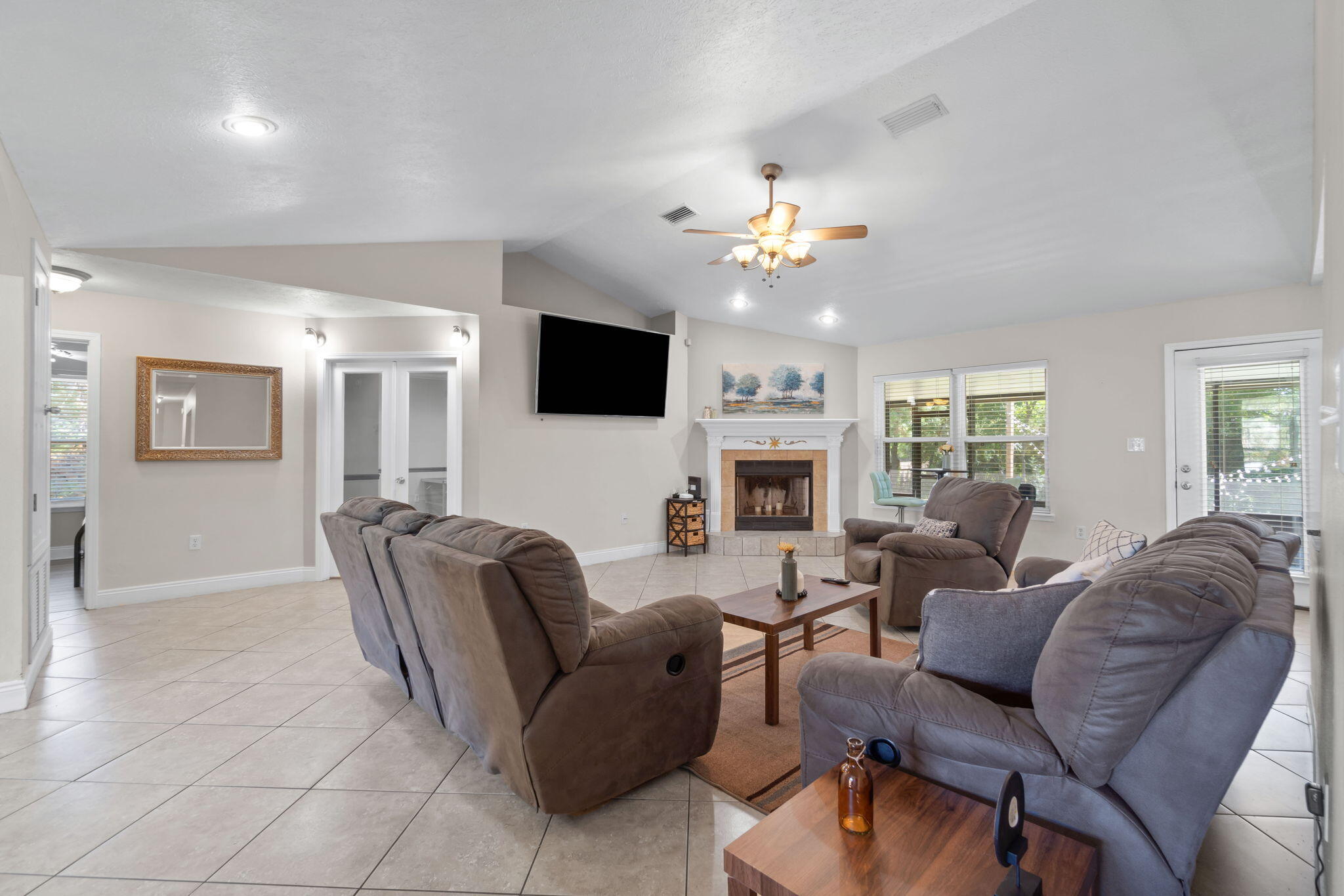 6983 Snug Waters Road Navarre, FL 32566 - Photo 9 of 48 a living room with furniture a fireplace and a flat screen tv