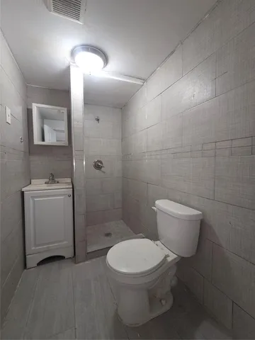 a white toilet sitting next to a bathroom sink and vanity