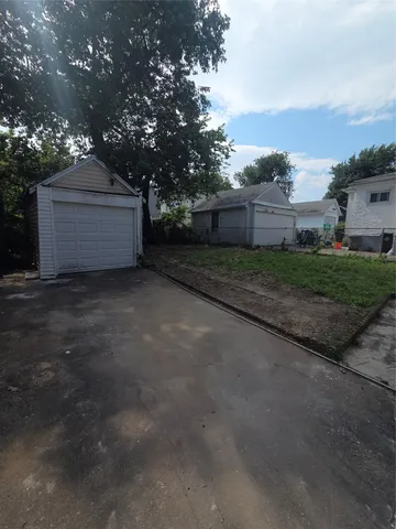 a view of a house with a yard and large tree