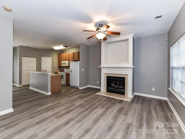 a view of a livingroom with a fireplace a chandelier and wooden floor