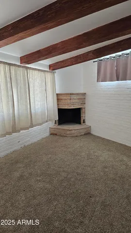 a view of an empty room with a fireplace and a window