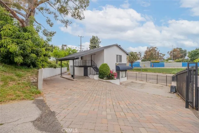 a view of a house with a yard and potted plants