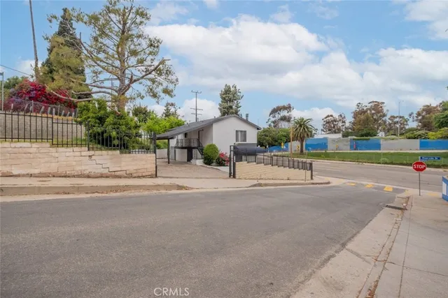 a view of a house with a big yard and large trees