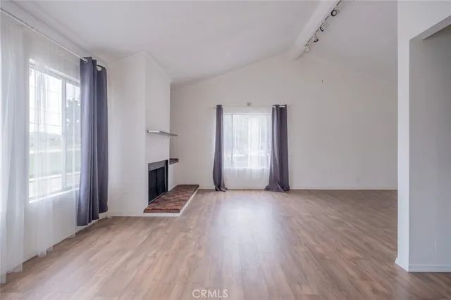 a view of a livingroom with wooden floor and windows