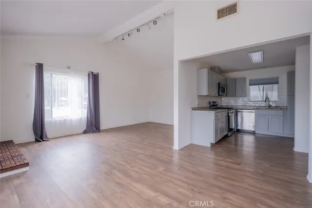 a view of a kitchen with a sink stove cabinets and empty room