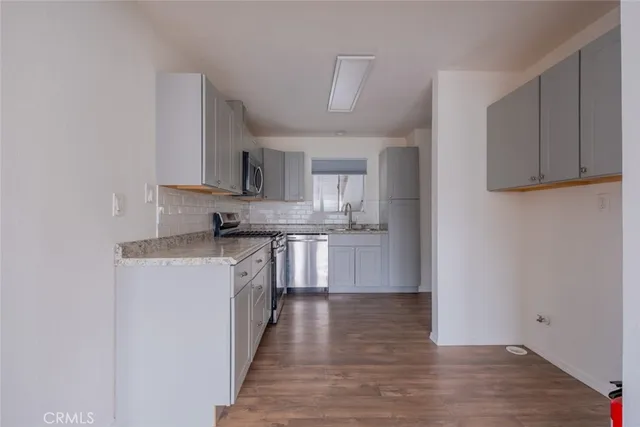 a kitchen with stainless steel appliances granite countertop a stove a sink and a refrigerator