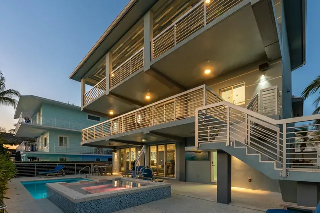 a view of yellow house with a large window and potted plants