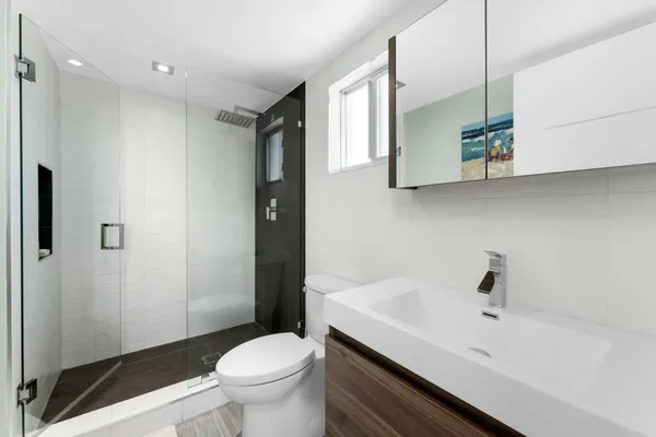 a bathroom with a sink and mirror with toilet