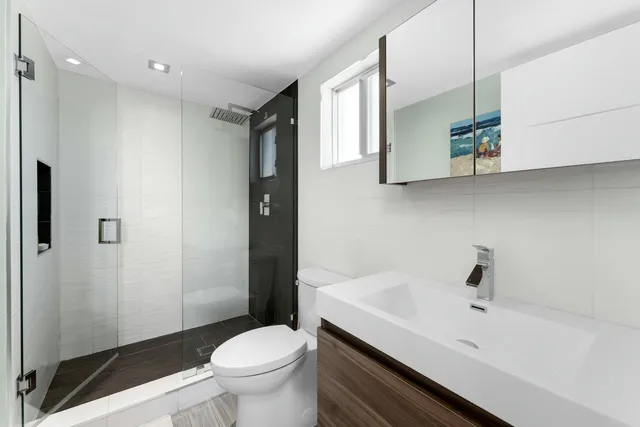 a bathroom with a sink and mirror with toilet