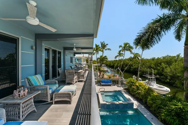 a living room with patio furniture and a potted plant