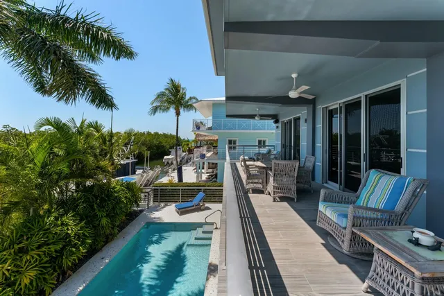 a view of a lake with a table and chairs in patio