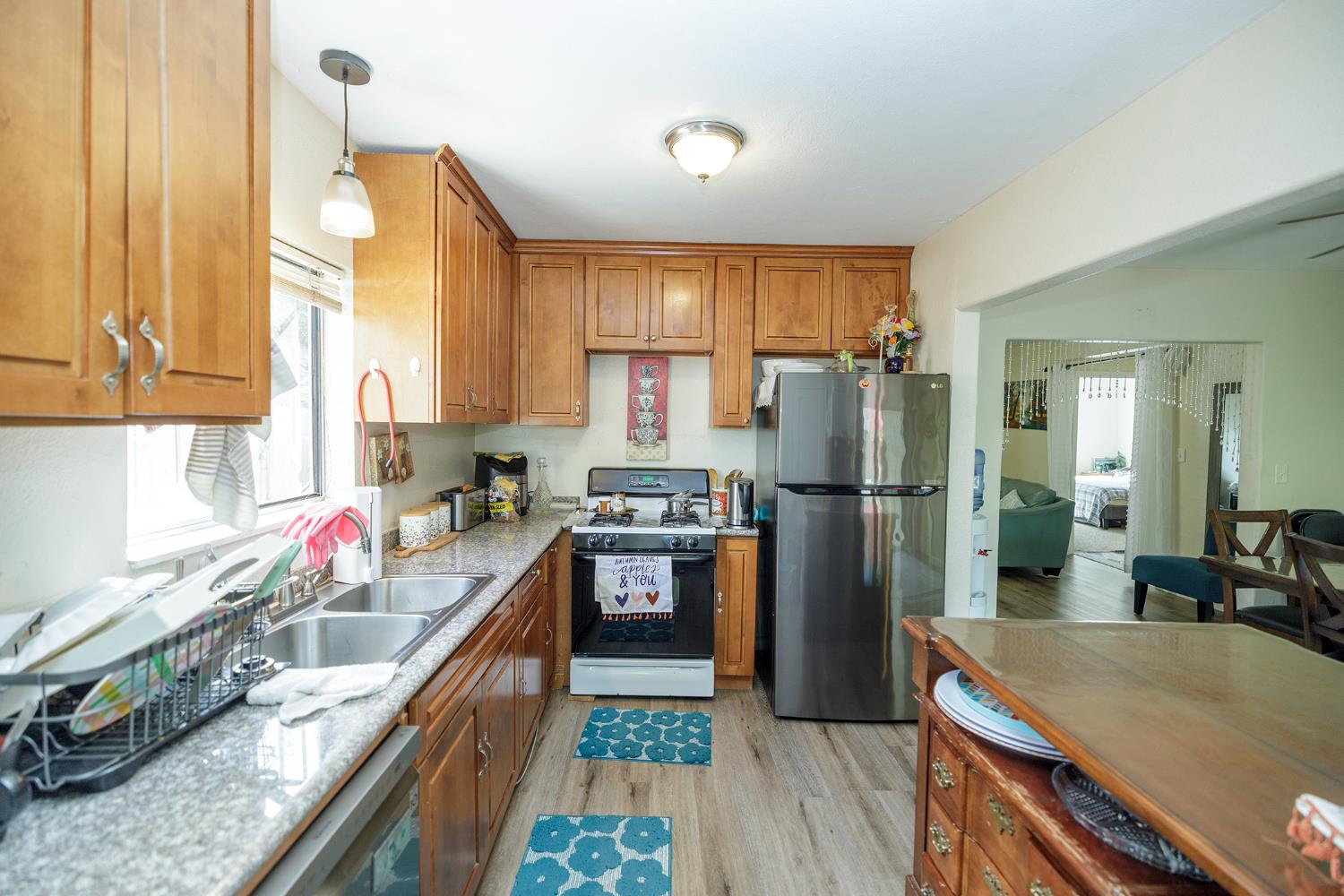 421 East 8th Street Stockton, CA 95206 - Photo 12 of 20 a kitchen with stainless steel appliances granite countertop a refrigerator a sink dishwasher a stove and white countertops with wooden floor