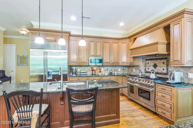 a kitchen with stainless steel appliances granite countertop a stove a sink and cabinets