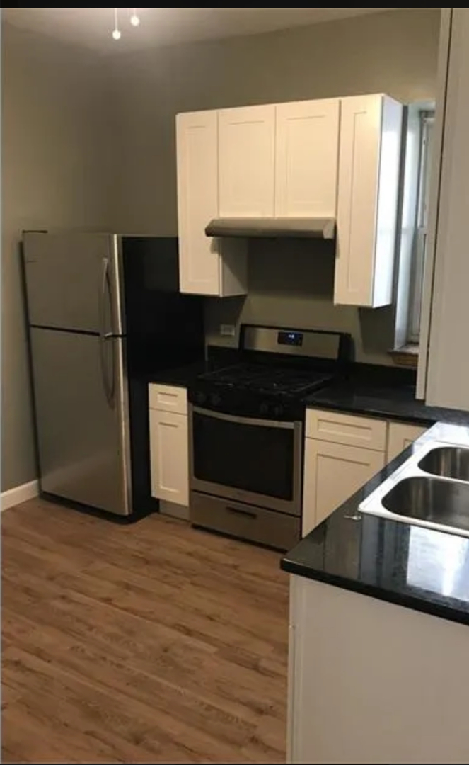 1808 South Drake Avenue Chicago, IL 60623 - Photo 2 of 14 a kitchen with kitchen island granite countertop a sink and a stove