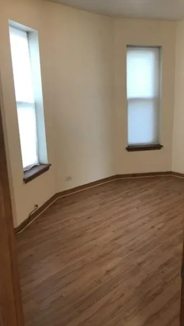 1808 South Drake Avenue Chicago, IL 60623 - Photo 6 of 14 an empty room with wooden floor and windows