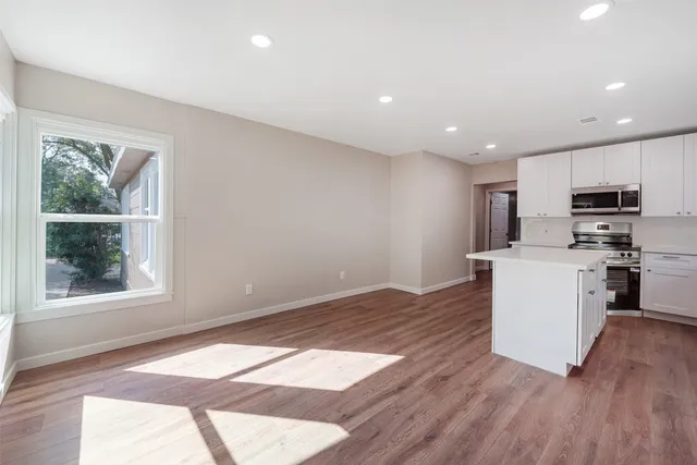 a view of kitchen with wooden floor and electronic appliances