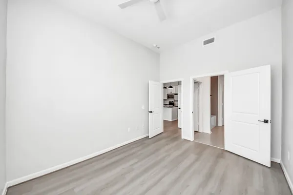 an empty room with wooden floor and windows