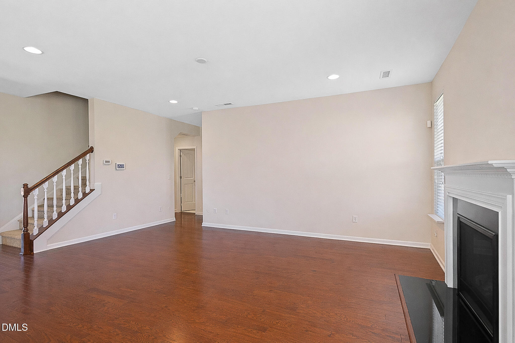 4249 Saubranch Hill Street Raleigh, NC 27616 - Photo 10 of 31 a view of an empty room with wooden floor and a fireplace