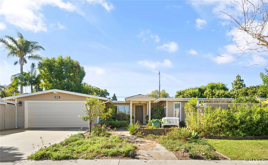 a front view of a house with a yard and potted plants