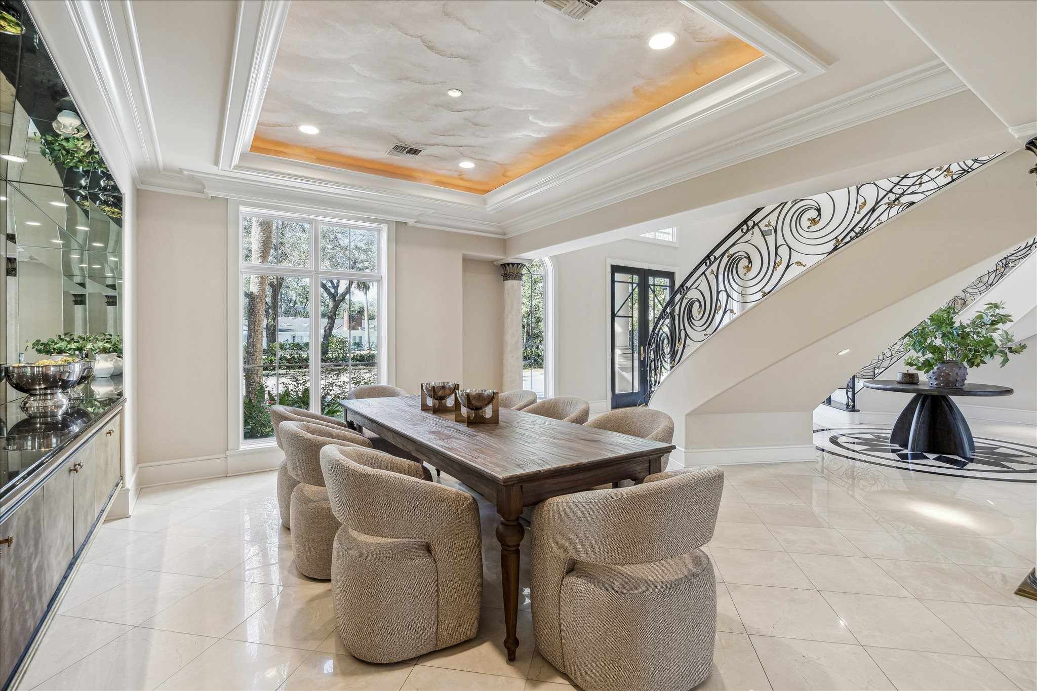 608 Little John Lane Houston, TX 77024 - Photo 19 of 46 This alternate view highlights the formal dining room’s graceful proportions and tray ceiling, accented by double crown molding and recessed lighting. Western-facing windows bring in warm natural light, enhancing the designer neutral wall palette. The space offers an inviting, polished setting ideal for hosting memorable dinners.