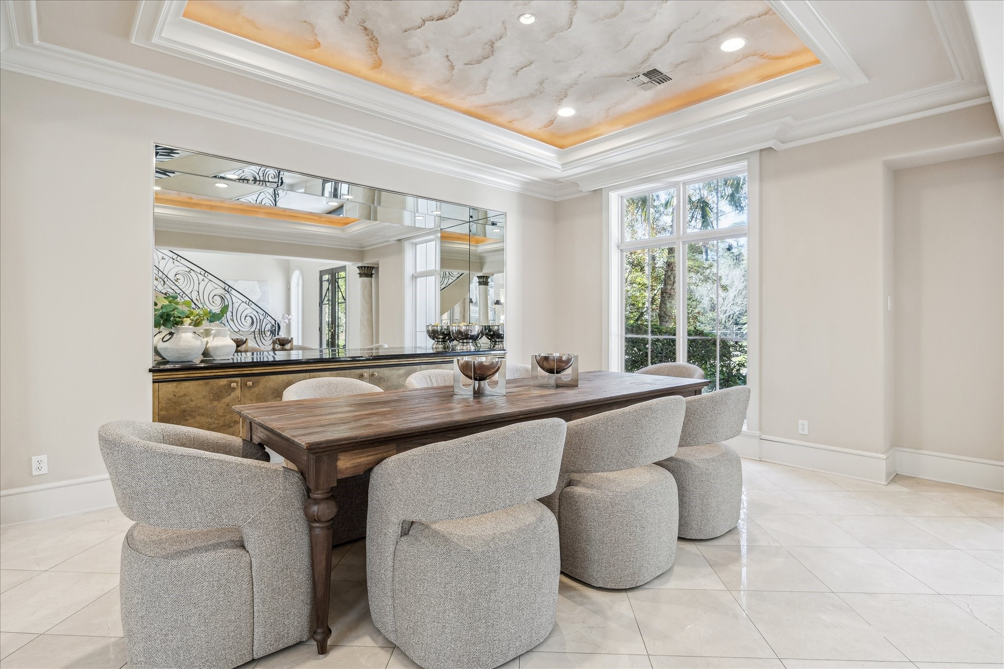 608 Little John Lane Houston, TX 77024 - Photo 20 of 46 The formal dining room is an elegant setting featuring a mirror-backed niche with a custom built-in buffet topped in granite. Western-exposure windows fill the space with natural light, complemented by a tray ceiling, double crown molding, recessed lighting, and designer neutral wall tones. Thoughtfully positioned with seamless flow to surrounding living spaces, it is ideal for both intimate dinners and entertaining.
