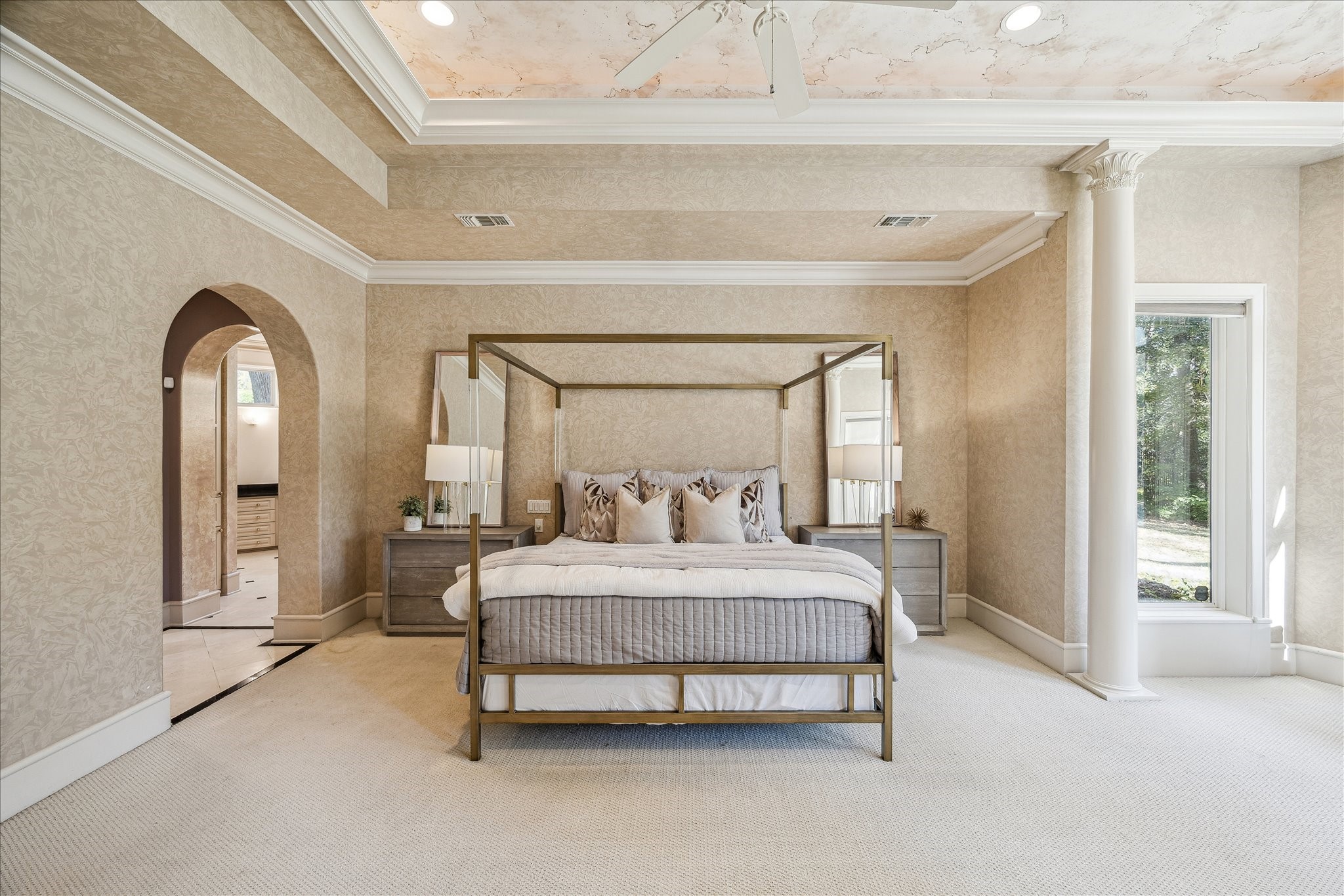 608 Little John Lane Houston, TX 77024 - Photo 27 of 46 Custom painted tray ceiling and wall treatments add a sophisticated, personalized touch to the primary retreat. Two spacious primary closets and a luxurious primary bath create a true spa-like experience, while access to the outdoors extends the living space. Double crown molding, a ceiling fan, and soft neutral tones complete this elegant and restful sanctuary.