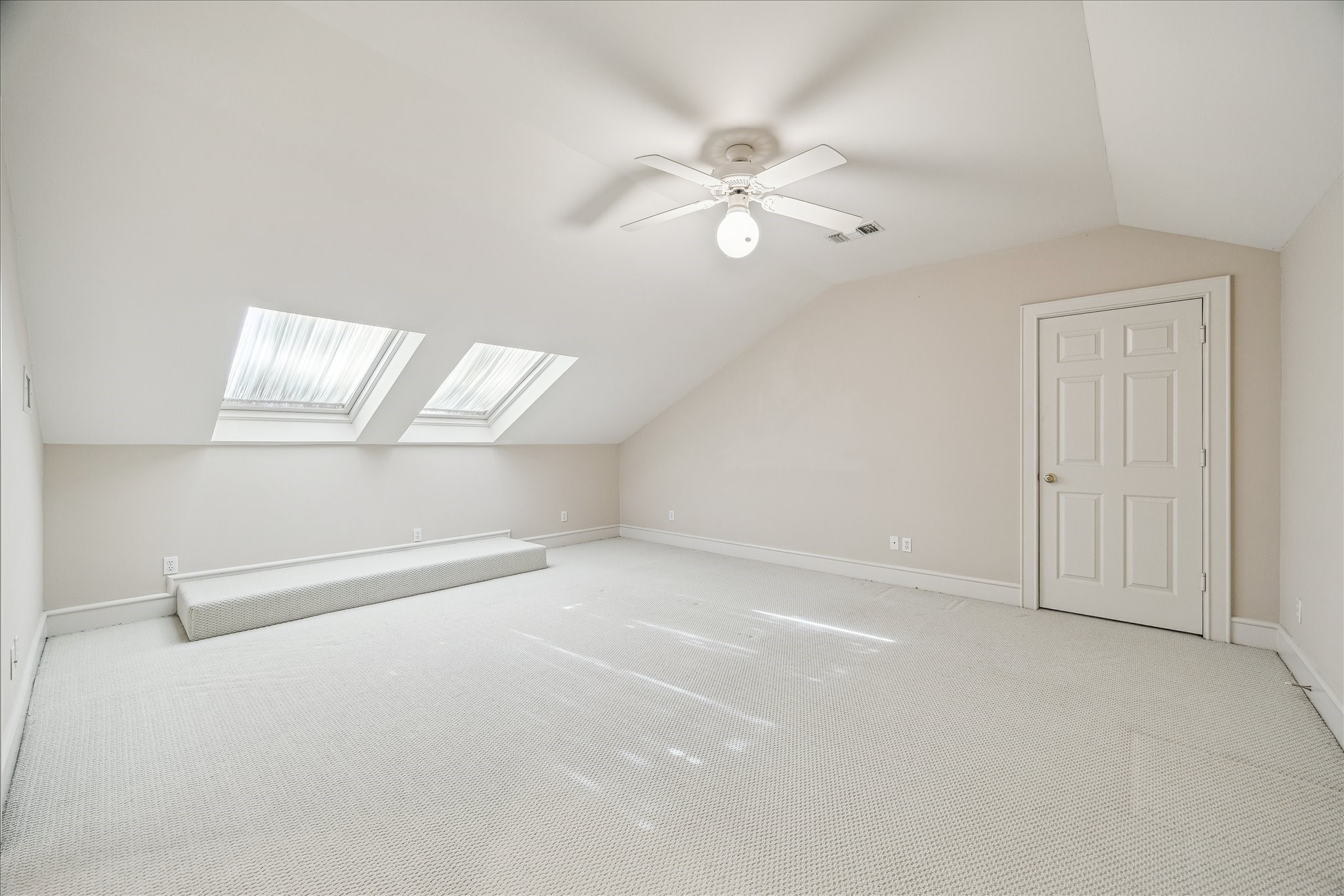 608 Little John Lane Houston, TX 77024 - Photo 38 of 46 Natural light streams through dual skylights, highlighting the designer neutral carpet and walls in this inviting guest bedroom. Ample storage is provided with a walk-in closet featuring long and short hanging sections and open shelving, perfect for guests.