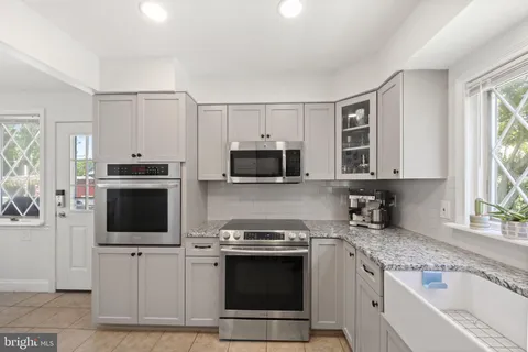 a kitchen with stainless steel appliances granite countertop a stove microwave and sink