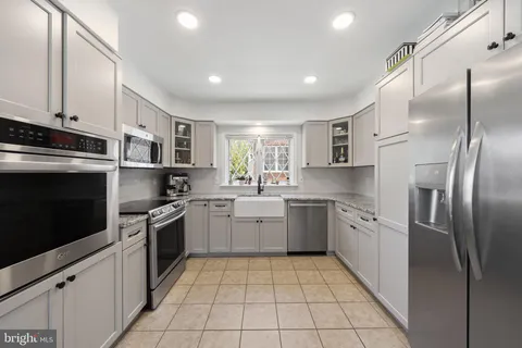 a kitchen with granite countertop stainless steel appliances cabinets a sink and a counter top space
