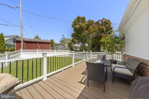 a balcony with wooden floor table and chairs