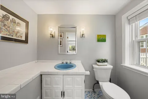 a bathroom with a toilet a sink and a window