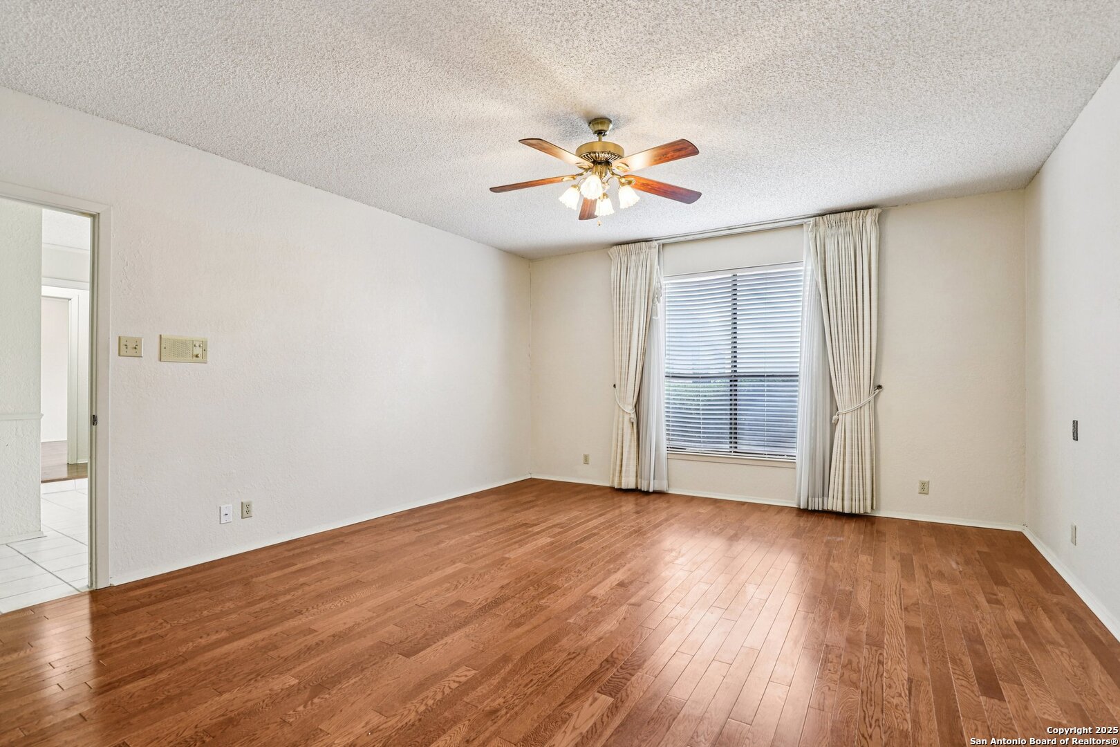 5817 Winding Ridge Drive Windcrest, TX 78239 - Photo 16 of 52 wooden floor in an empty room with a window