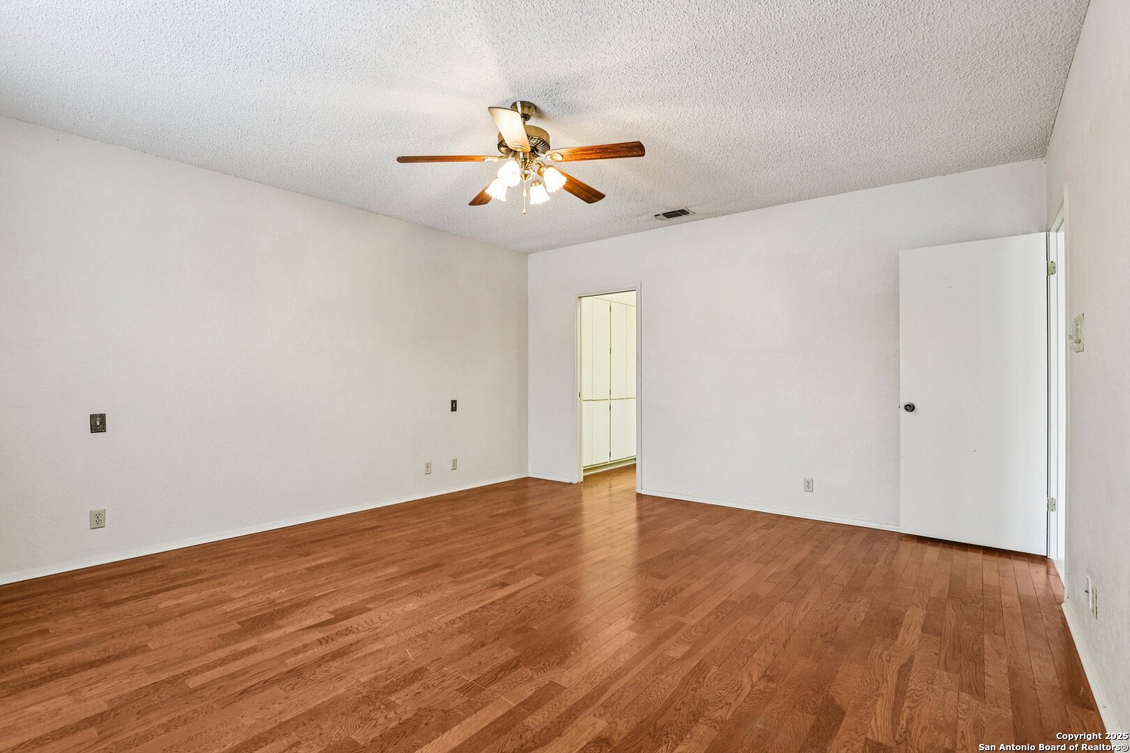 5817 Winding Ridge Drive Windcrest, TX 78239 - Photo 4 of 52 an empty room with wooden floor fan and windows