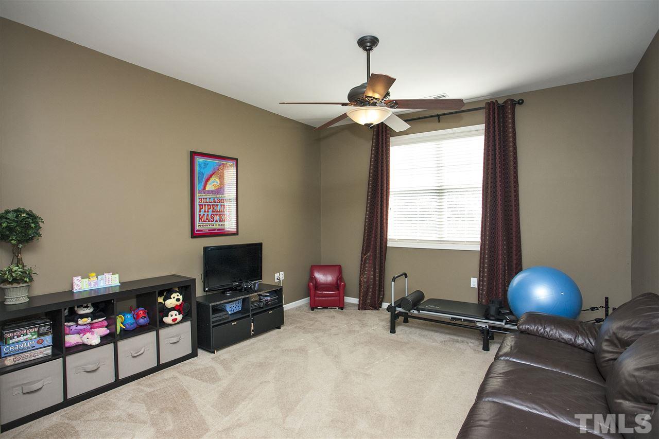 8621 Benzinger Drive Raleigh, NC 27613 - Photo 21 of 25 a bedroom with furniture a flat screen tv and a window