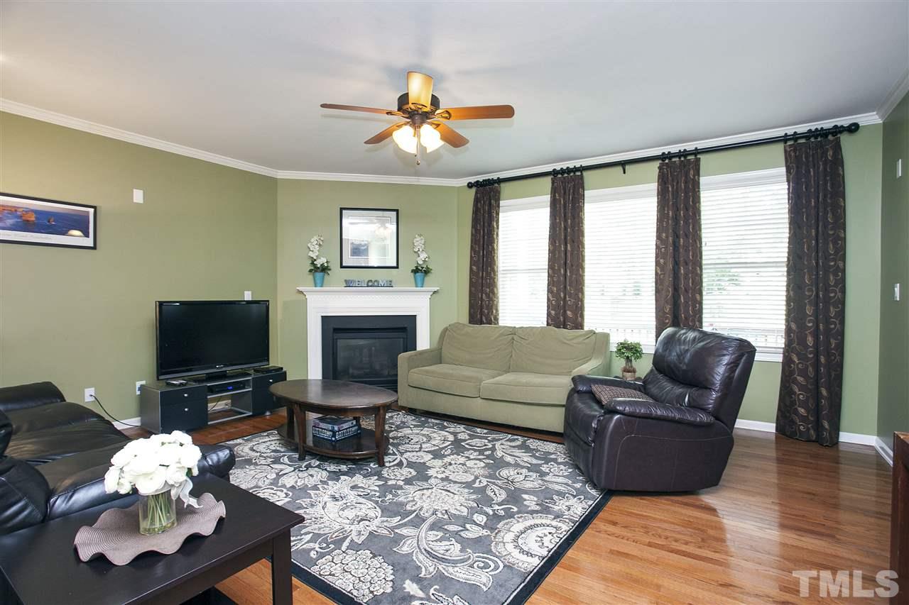 8621 Benzinger Drive Raleigh, NC 27613 - Photo 5 of 25 a living room with furniture a fireplace and a flat screen tv