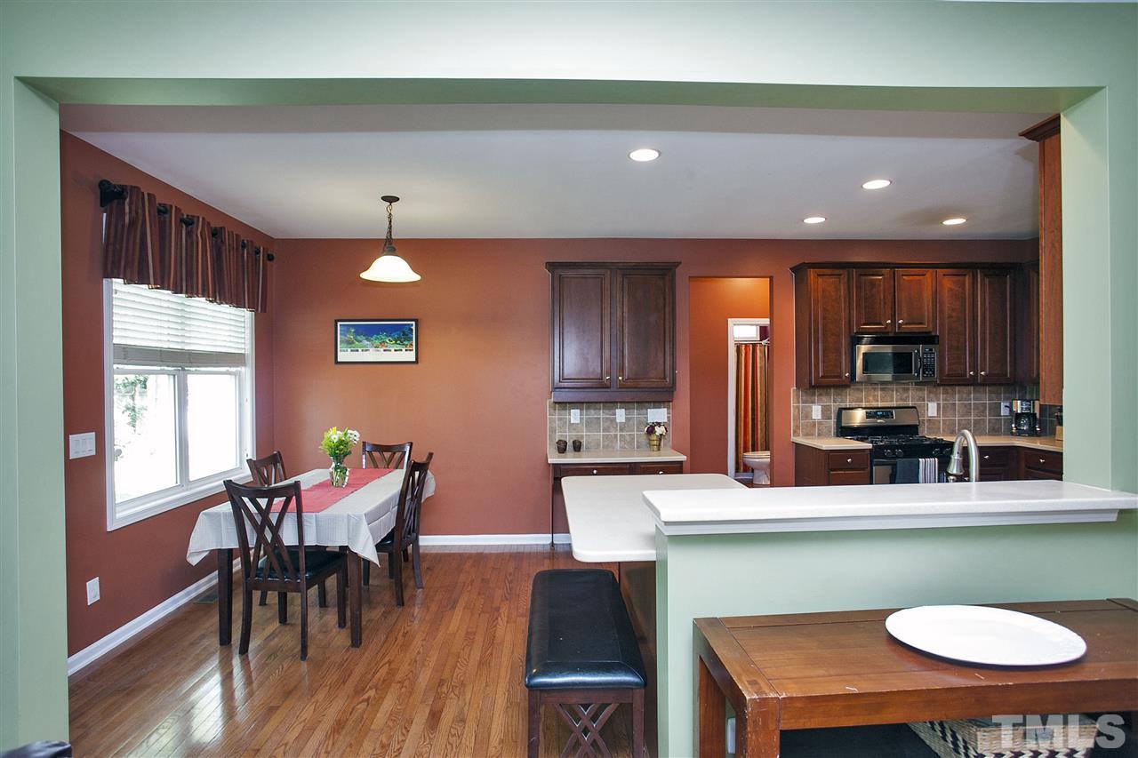 8621 Benzinger Drive Raleigh, NC 27613 - Photo 7 of 25 a kitchen with a dining table chairs and refrigerator