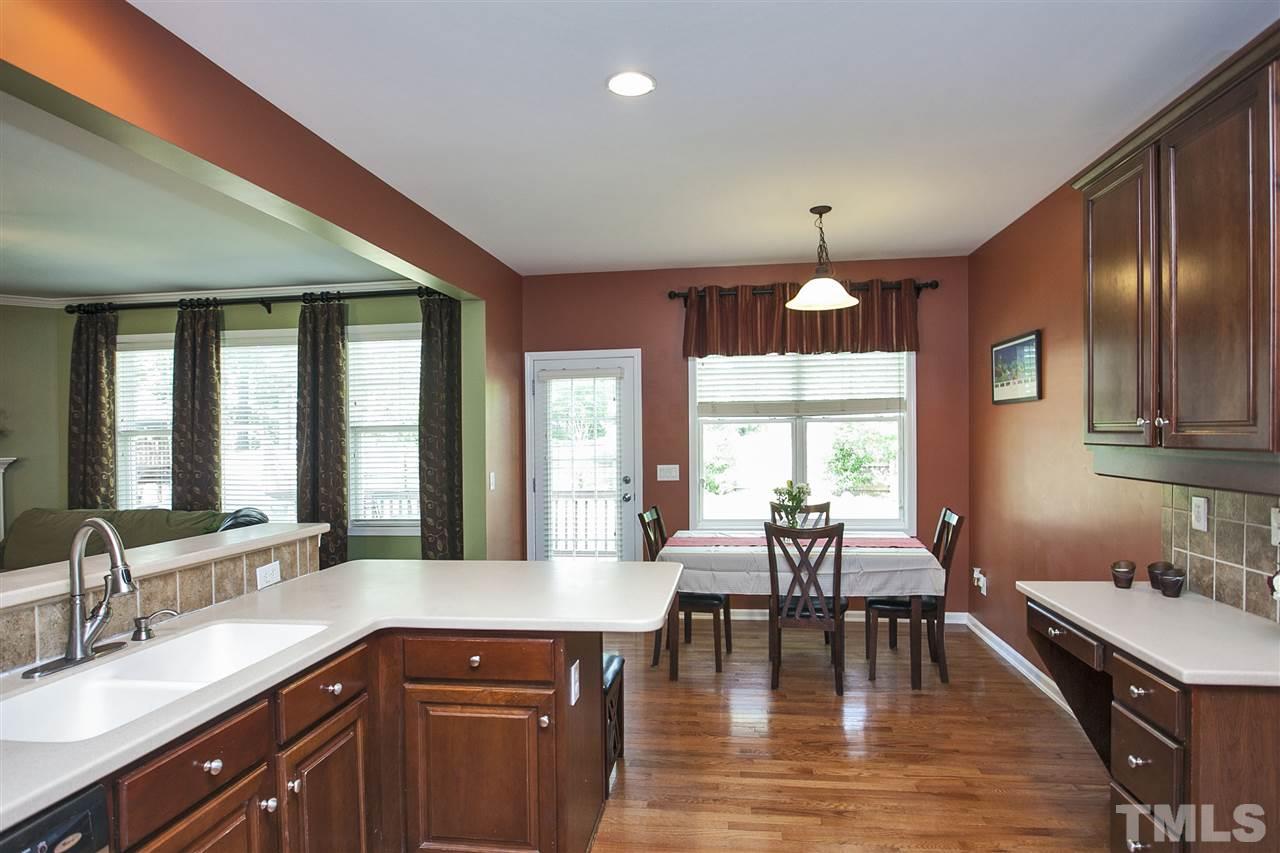 8621 Benzinger Drive Raleigh, NC 27613 - Photo 9 of 25 a kitchen with a dining table chairs wooden floor and appliances