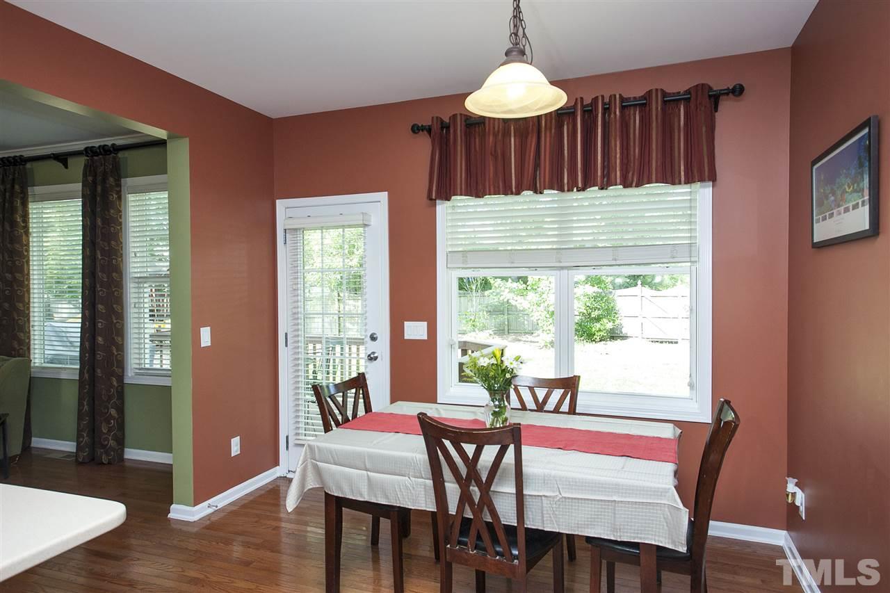 8621 Benzinger Drive Raleigh, NC 27613 - Photo 10 of 25 a dining room with furniture a chandelier and wooden floor