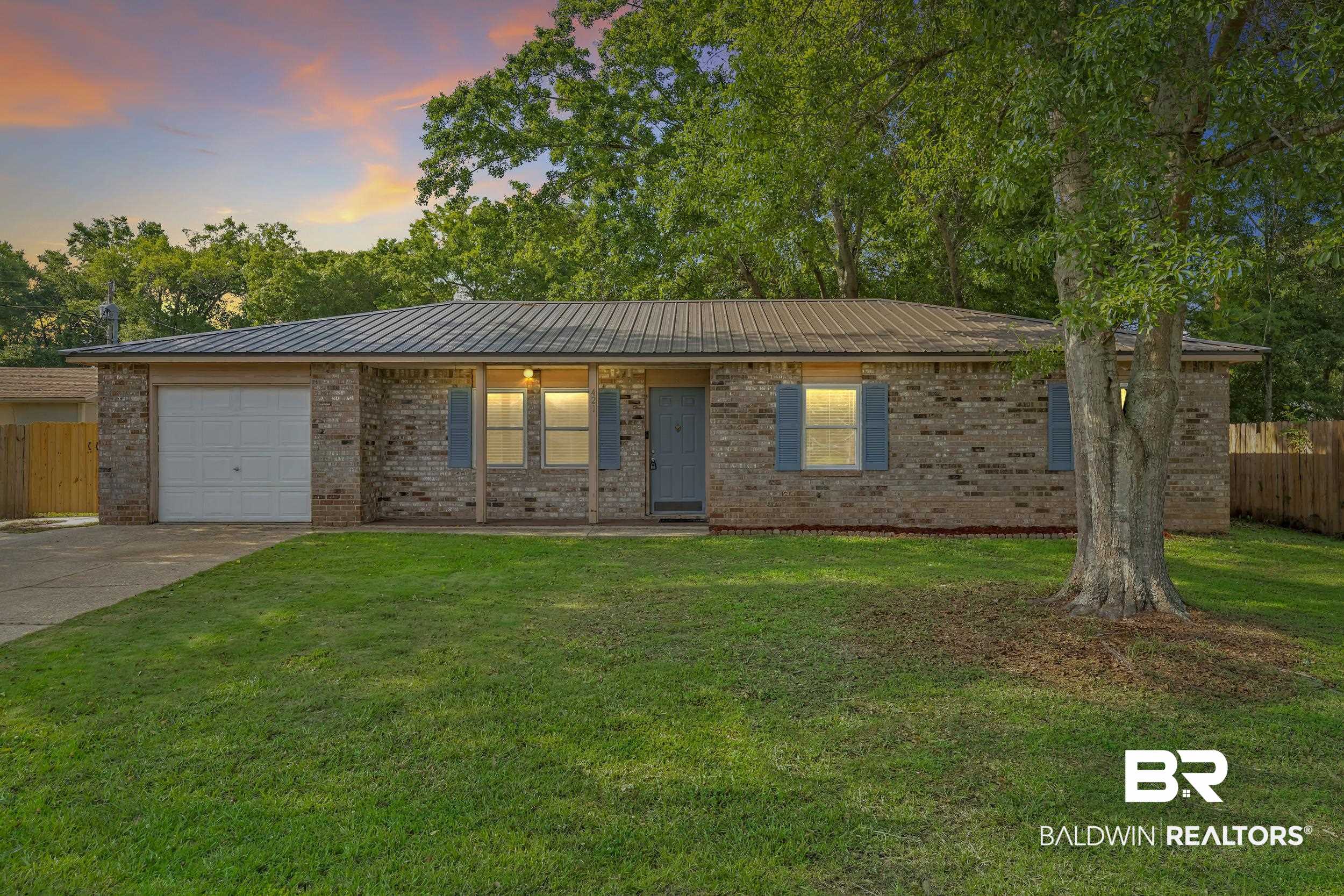 421 Cedar Court Foley, AL 36535 - Photo 2 of 39 Brick exterior featuring blue shutters, a metal roof, and an attached garage
