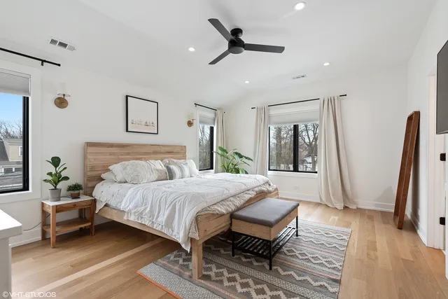 a bedroom with a bed a couch and a large mirror on the dresser