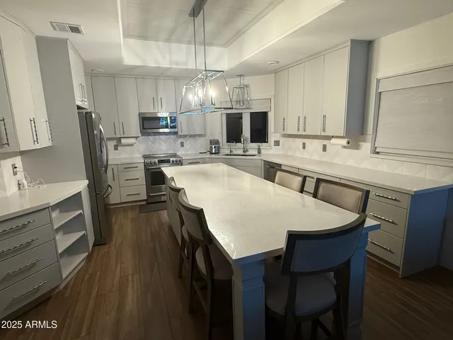 a large kitchen with a table and chairs