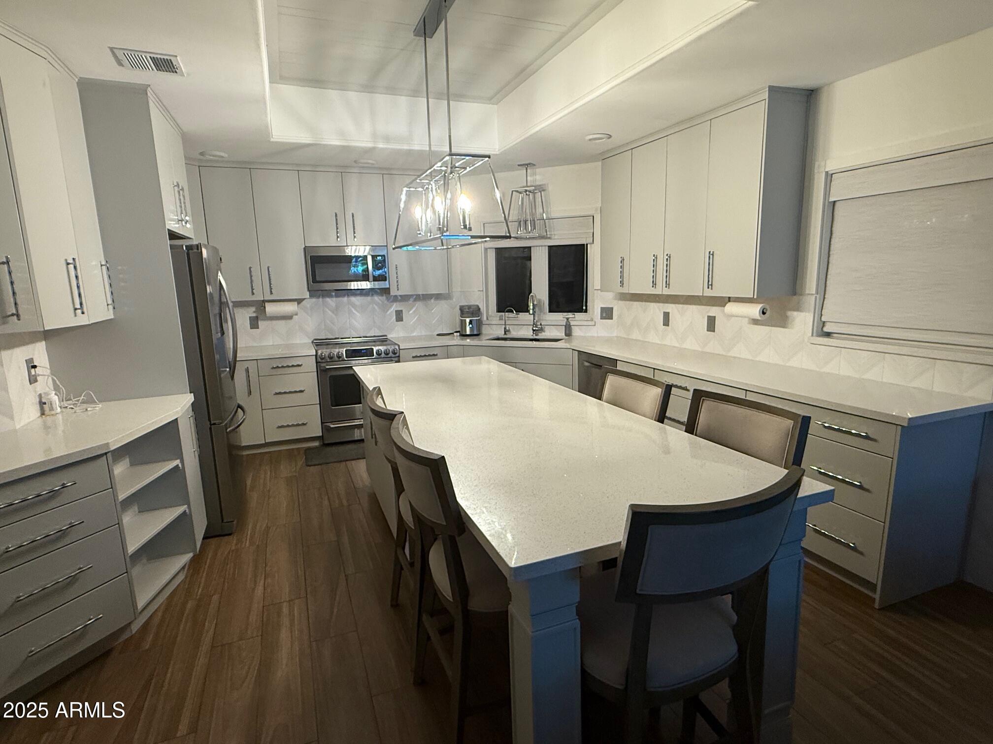 4055 North Recker Road, Unit 62 Mesa, AZ 85215 - Photo 27 of 47 a large kitchen with a table and chairs