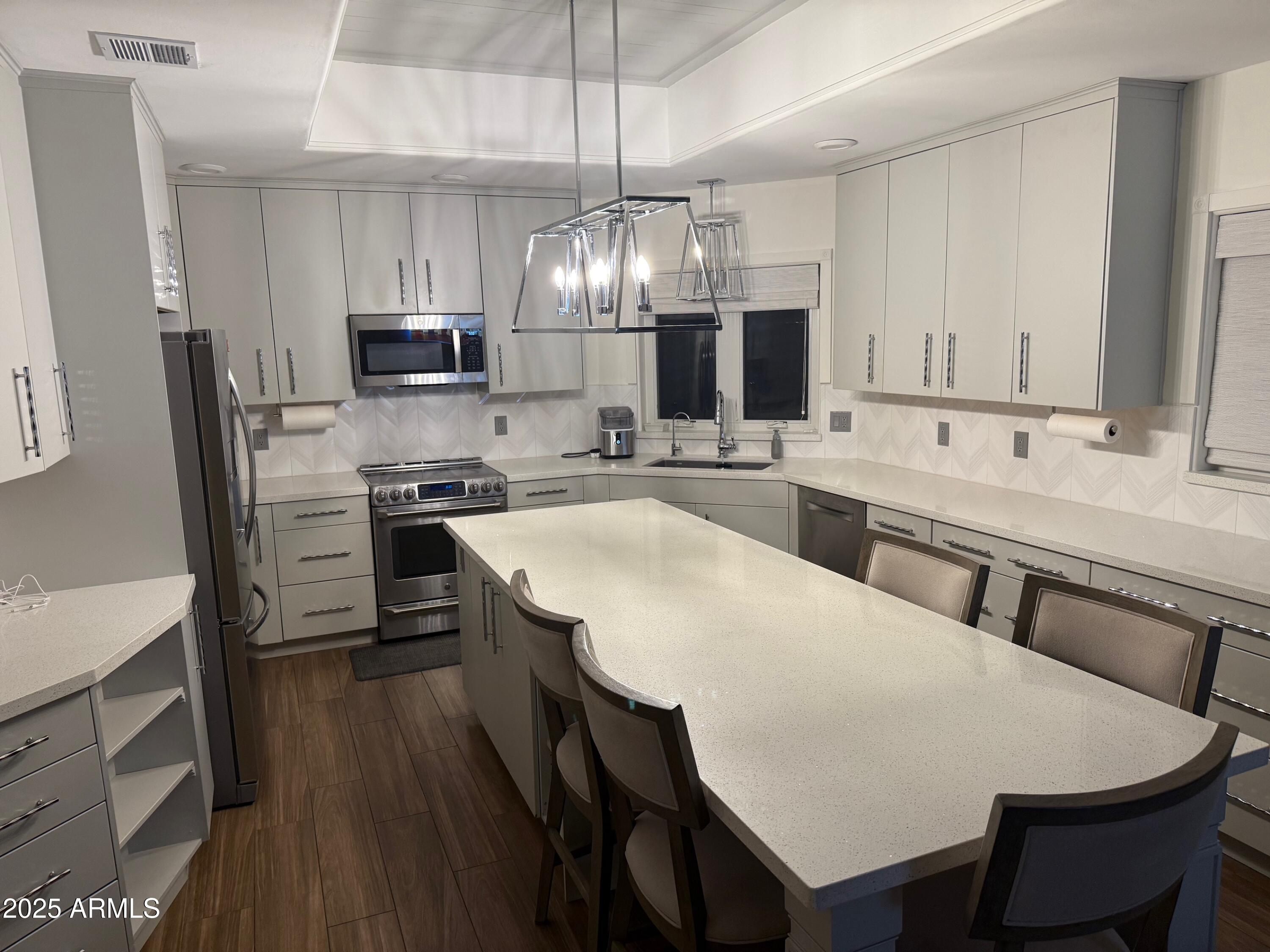 4055 North Recker Road, Unit 62 Mesa, AZ 85215 - Photo 28 of 47 a large kitchen with a table and chairs