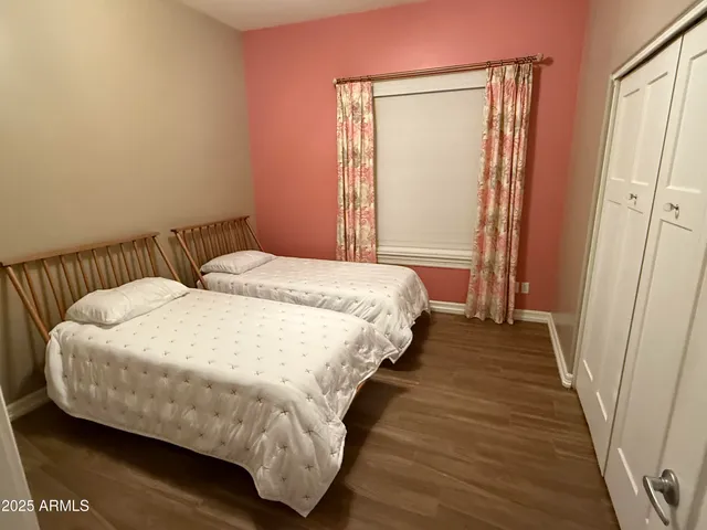 a bedroom with a bed and a wooden floor