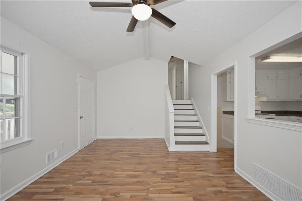 1496 Cherry Hill Road Southwest Conyers, GA 30094 - Photo 2 of 32 a view of a kitchen with wooden floor and a ceiling fan