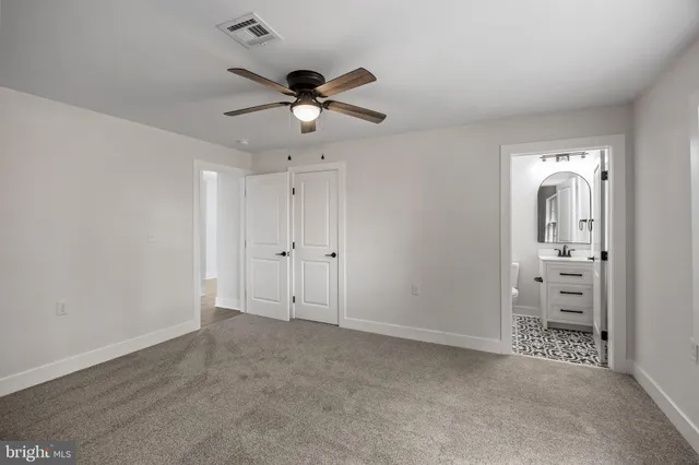 an empty room with closet and a chandelier fan