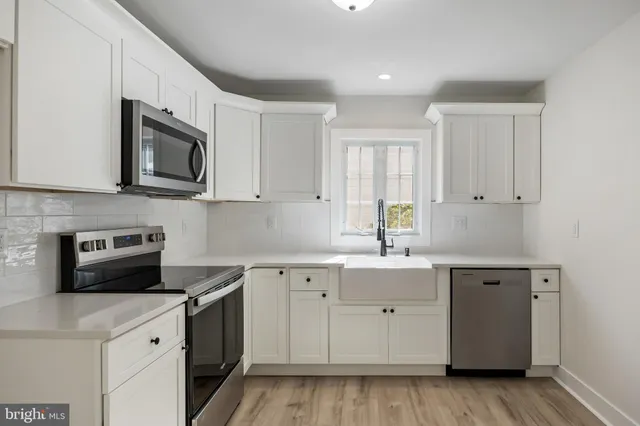 a kitchen with a sink stove and microwave