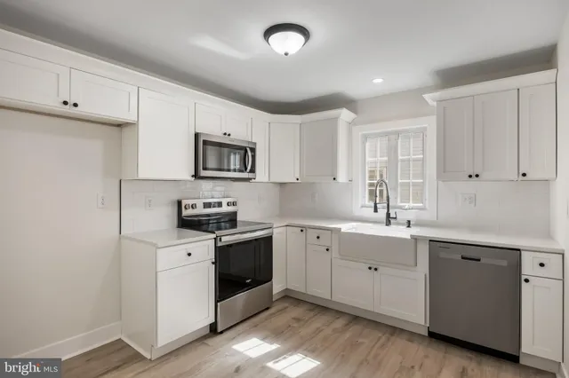 a kitchen with sink a microwave and cabinets